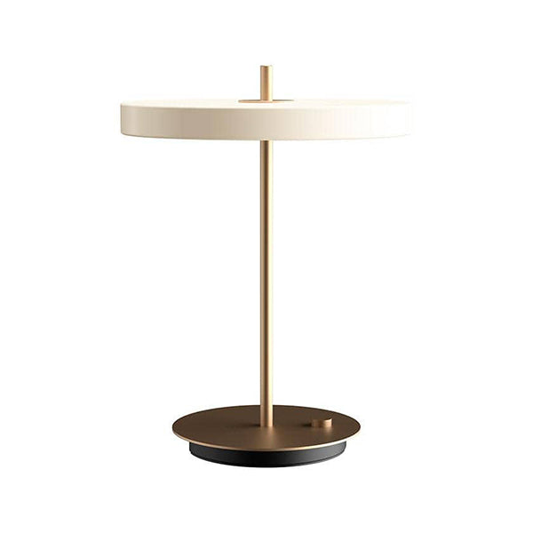 La lampe de table Asteria par Umage dispose d'un panneau LED intégré avec un diffuseur assurant un éclairage doux dans la pièce.