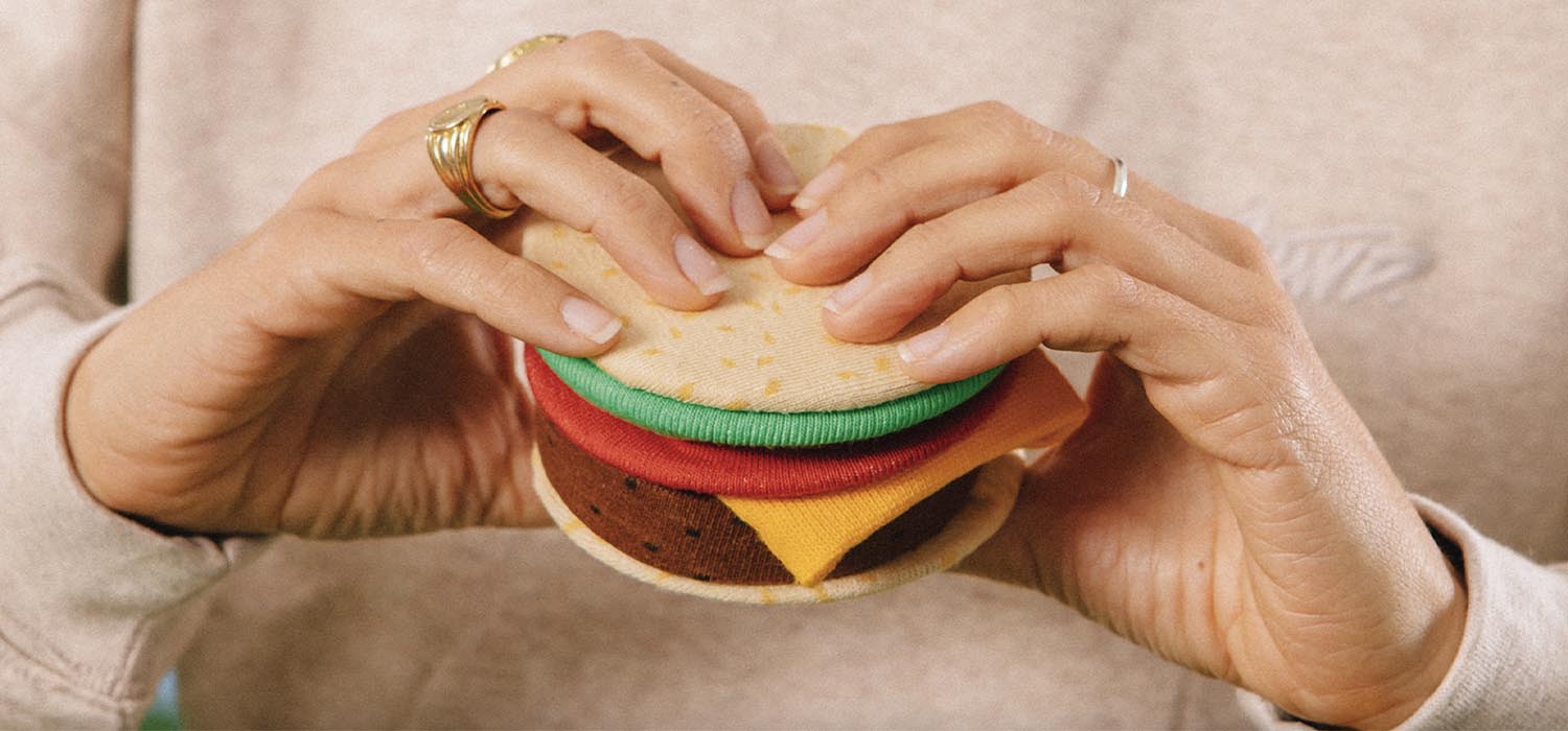 Une paire de bas, par Eat My Socks, qui sont amusants et confortables en forme de cheeseburger. Seulement pour les vrais fans de ces délicieux burgers. C'est-à-dire tout le monde !