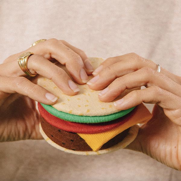 Une paire de bas, par Eat My Socks, qui sont amusants et confortables en forme de cheeseburger. Seulement pour les vrais fans de ces délicieux burgers. C'est-à-dire tout le monde !