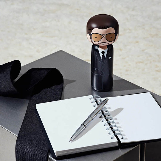 Tom Ford rencontre l'artisanat japonais dans la poupée Kokeshi Tom de Lucie Kaas. Sculptée à la main en bois, cette figurine élégante incarne le luxe et la sophistication. Un must pour les amateurs de design et les admirateurs de Tom Ford.