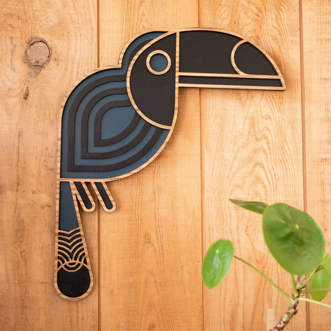 Apportez une touche d'exotisme à votre décoration avec le toucan en bois de Minimum Design, une création élégante et colorée.