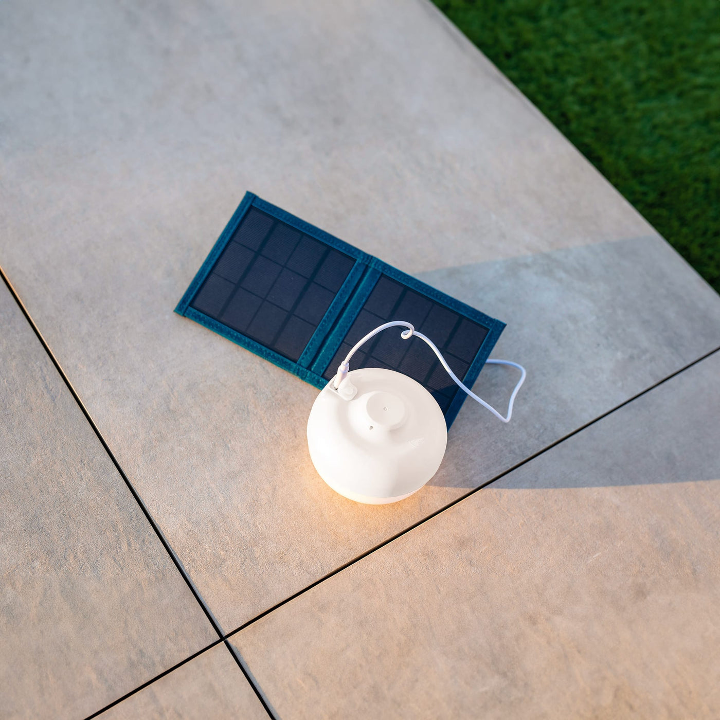Cherry par Newgarden : lampe de table avec base aimantée, panneau solaire pliable pour une recharge écologique en camping.