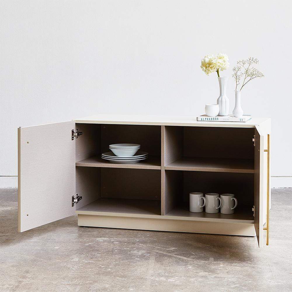 Dotée d'une finition satinée lisse, de poignées plaquées en laiton et de portes découpées avec précision sur une plate-forme surélevée, le cabinet Elora de Gus* Modern offre un vaste espace de rangement dans une forme minimaliste et contemporaine