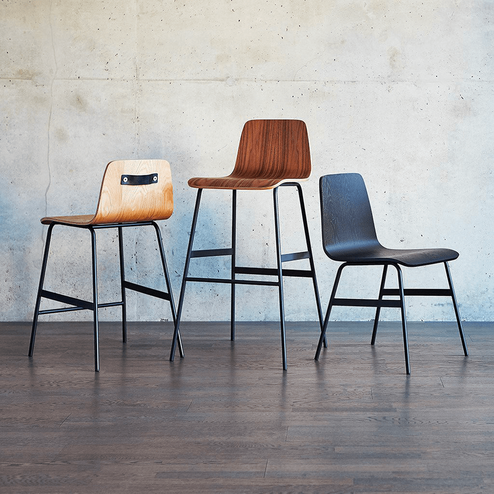 Le tabouret de comptoir, tabouret de bar ou la chaise Lecture de Gus* Modern sont une ré-interprétation moderne d'une chaise d'école primaire classique. L'assise et le dossier sont en contreplaqué cintré d'une seule pièce, avec une poignée en cuir et laiton