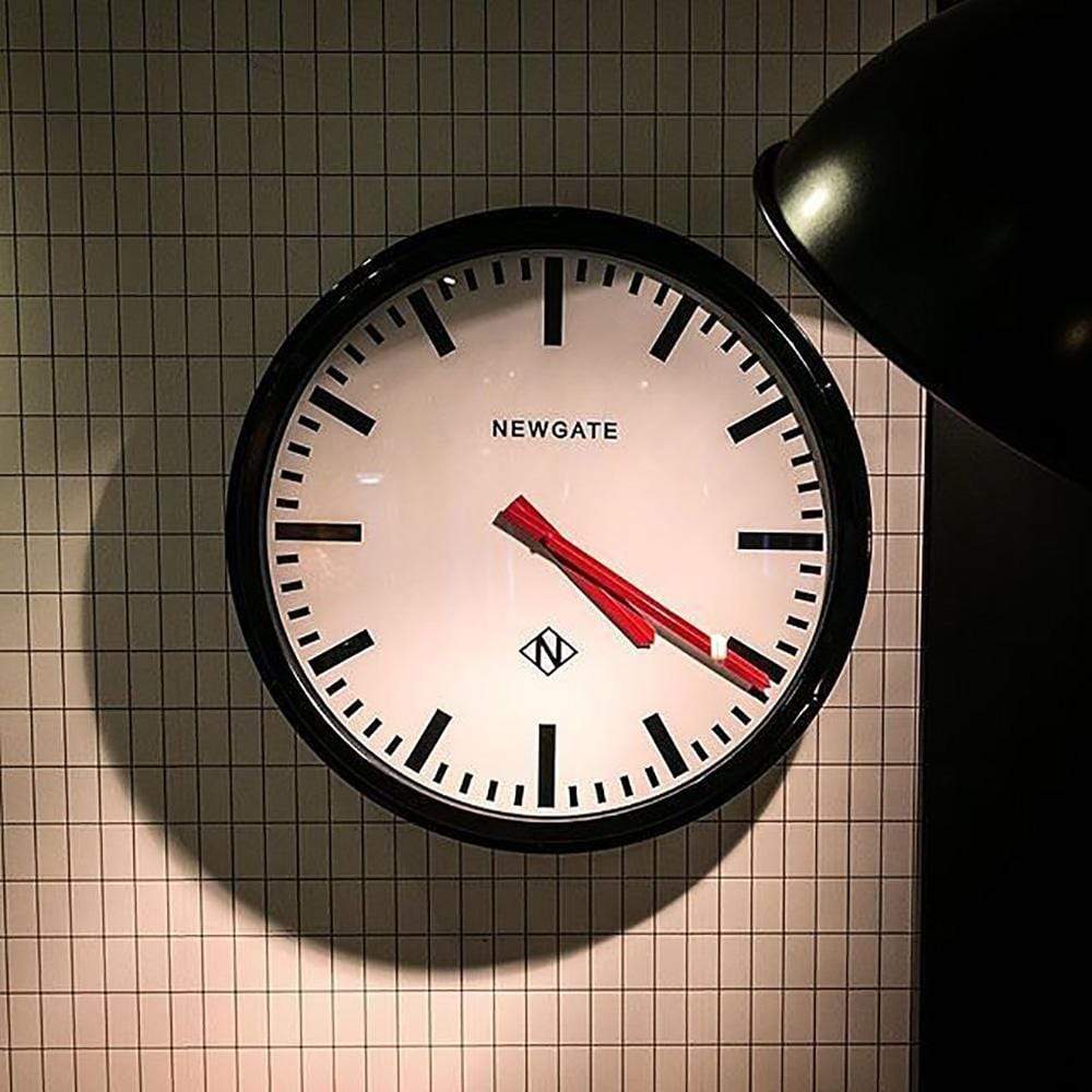 Transformez votre espace avec Metropolitan de Newgate : une horloge murale au boîtier en métal peint, disponible en noir ou en chrome, pour une esthétique industrielle saisissante.