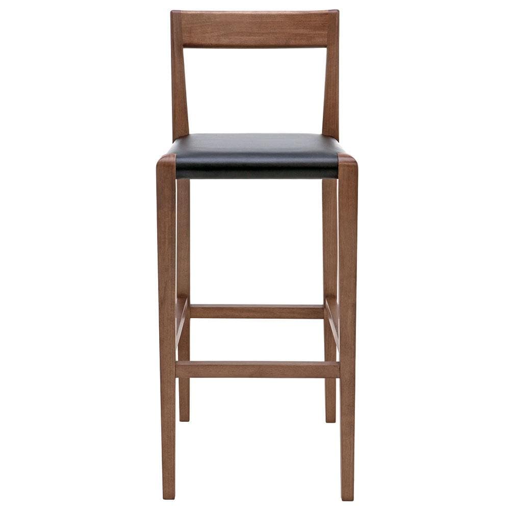 Optez pour le raffinement discret du tabouret Ameri dans votre cuisine. Son bois massif teinté noyer et son cuir noir offrent un contraste saisissant et une sophistication subtile.