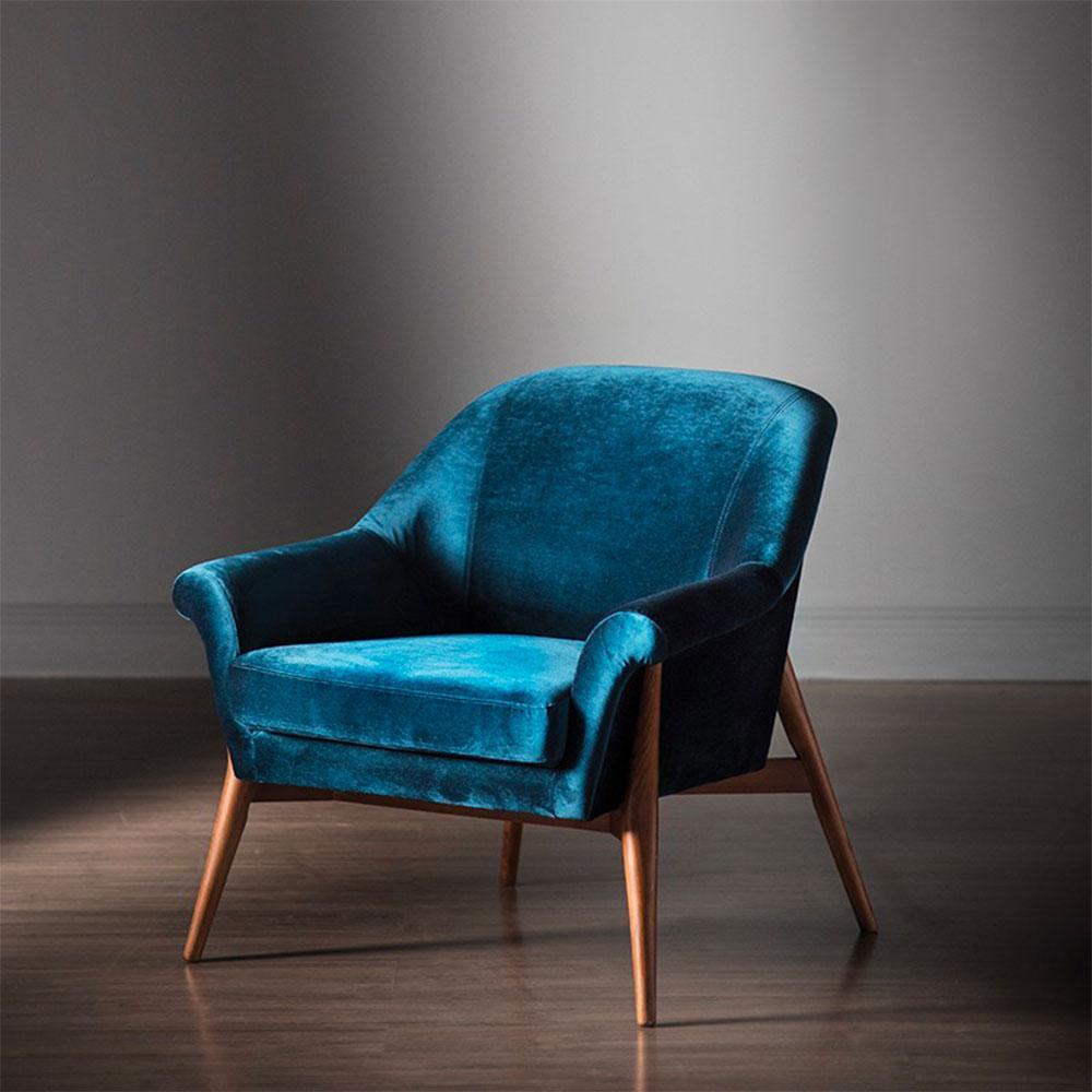 Fauteuil Charlize : élégance classique avec une touche de modernité néo-romane. Profil majestueux, pieds en noyer massif et confort somptueux en velours.