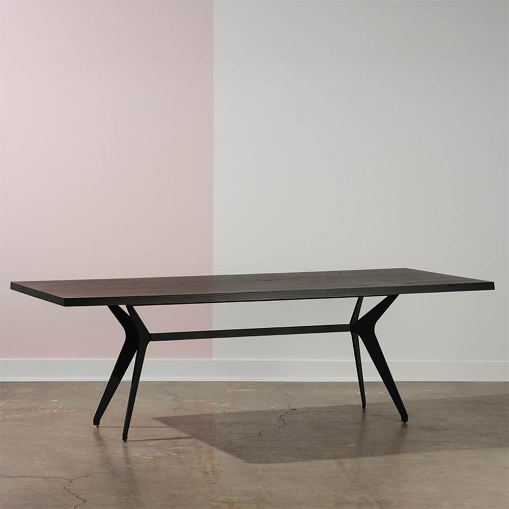 La table à manger Daniele de Nuevo marie élégance et modernité, avec des pieds en acier noir et un choix entre céramique chic ou chêne chaleureux pour une salle à manger sophistiquée.