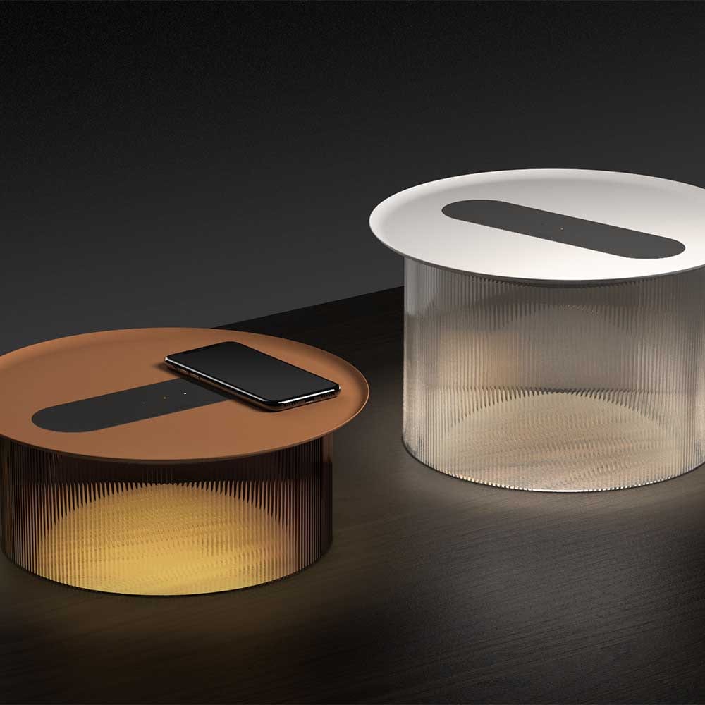 La lampe de table Carousel par Pablo Designs estompe la frontière entre l'ambiance et l'utilité en combinant un plateau de recharge sans fil à faible encombrement pour vos appareils mobiles avec un éclairage chaleureux et non éblouissant.