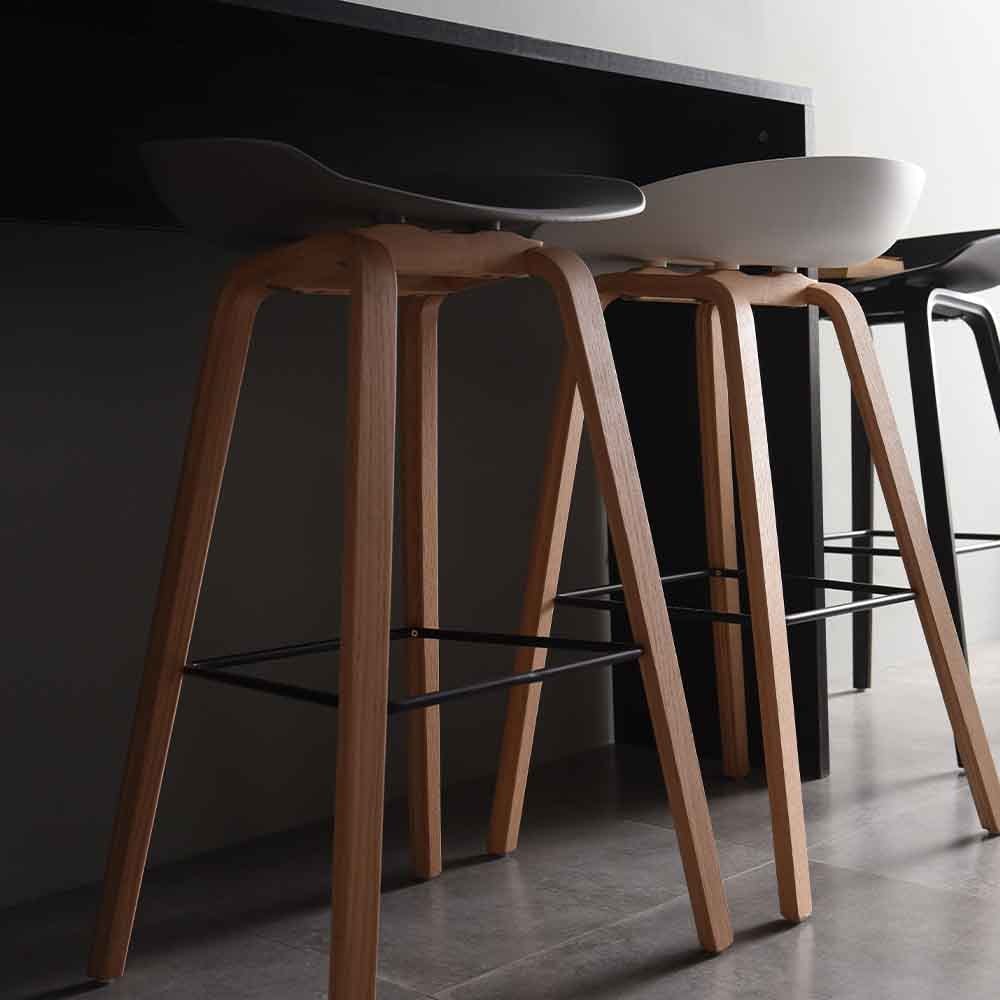 Le tabouret de comptoir About est fabriqué avec l'assise en polypropylène et la base en bois.