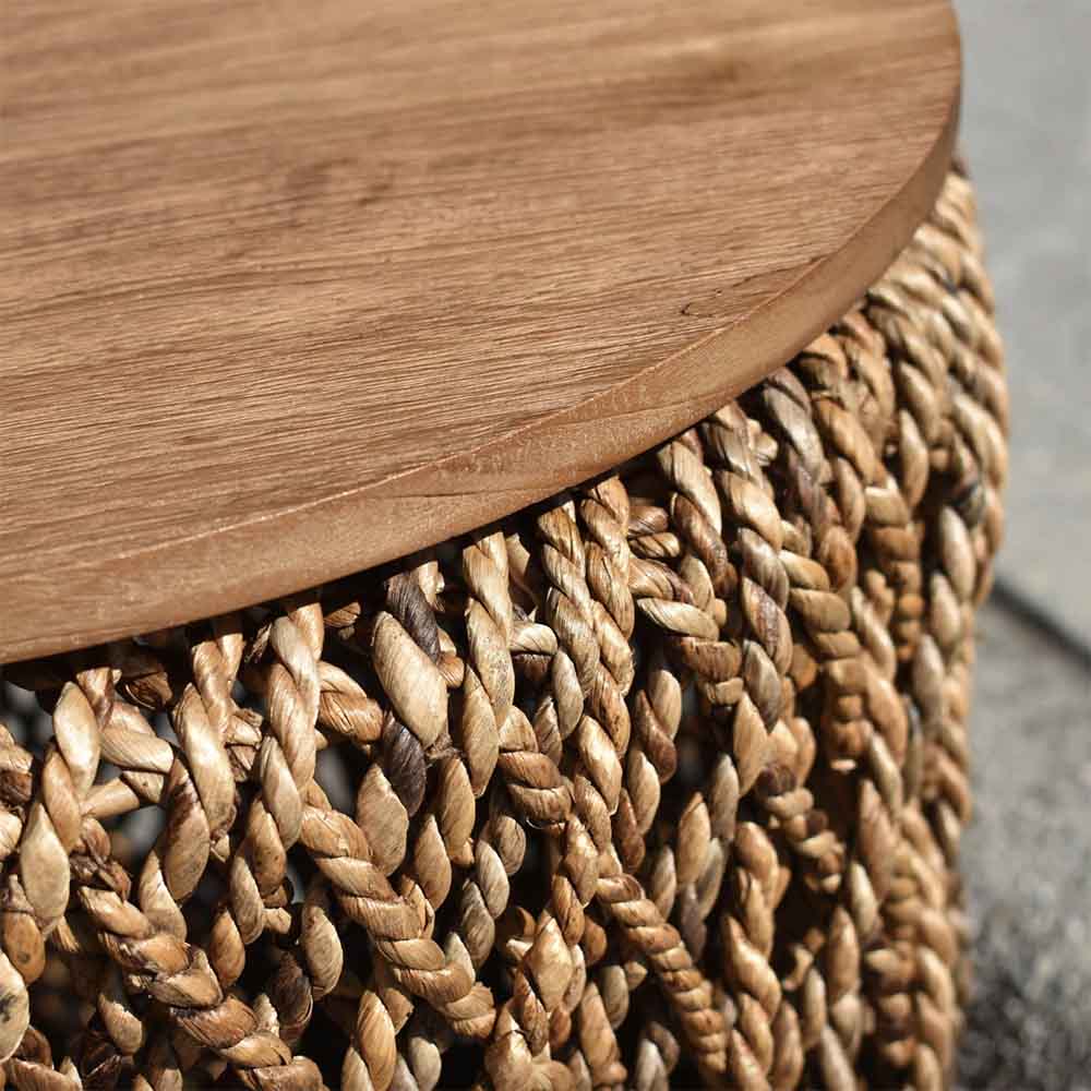 Élégance naturelle avec la table à café Knut. Base en abaca tissée à la main, plateau en teck recyclé aux motifs uniques. Polyvalence intégrée : le plateau devient un panier discret.